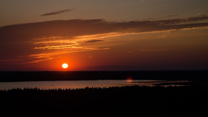 Wall Mural - Colorful sunset on lake Usma in Latvia. Above the tops of the trees.