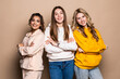 © F8  \ Suport Ukraine - Three women friends with crossed hands standing together on beige background