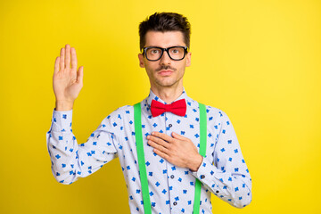 Poster - Photo of young serious man hand on chest hand on chest make swear devotion trust isolated over yellow color background