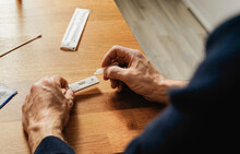 Corona Schnelltest - Using A Covid 19 Home Rapid Test - Test Liquid Is Filled Into The Test Cassette. Nasal Swab For A Home Health Check.