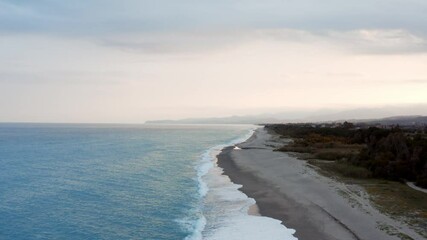 Wall Mural - Spiaggia al tramonto con nuvole e mare tempestoso vista aerea con mare a sinistra