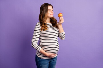 Poster - Photo of pretty dreamy lady waiting baby dressed striped shirt arm tummy enjoy fruit aroma isolated violet color background