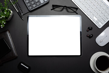 Black background office desk with tablet blank white screen with office supplies on the table. Mock up.