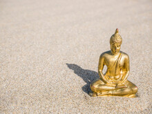 Small Golden Buddha Statue Or Buddharupa In The Sand