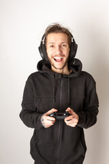 Young man with a gaming headset and controller having fun playing a video game. E-sports, video gaming, streaming concept