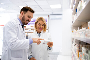 Wall Mural - Pharmacists working together in pharmacy store.