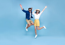 Happy Asian Couple Tourist Jumping Celebrating To Travel On Summer Holiday Isolated On Blue Background.