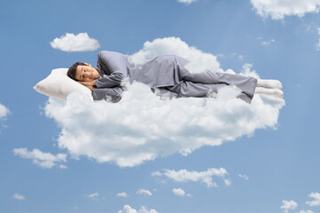 man in pajamas sleeping on a cloud and floating in the sky