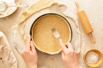 Wall Mural - Cheesecake cooking baking dessert step by step recipe, raw dough and cooking pan with female hands.