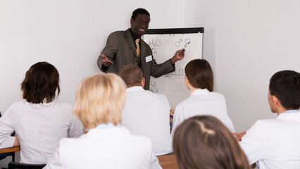 Wall Mural - Confident African American male doctor lecturing to colleagues at medical conference