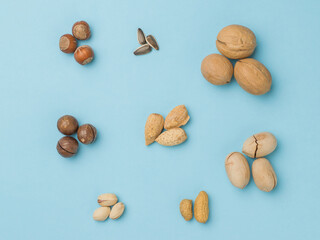 Wall Mural - Several sets of different nuts on a blue background. Flat lay.