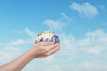 Canvas Print - globe, earth in human hands over blue sky background. idea for save the world. elements of this imag