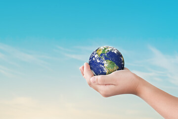 Canvas Print - environment day concept, globe in child hands over blue sky background. save of earth. elements of t