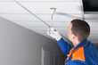 professional installation of hidden wiring and electrical appliances, installs a motion sensor in the suspended ceiling plate
