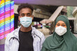 African man and African Muslim woman wearing face mask to protect from covid 19