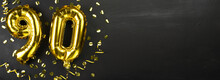 Golden Foil Balloon Number Ninety. Birthday Or Anniversary Card With The Inscription 90. Black Concrete Background. Anniversary Celebration. Banner.