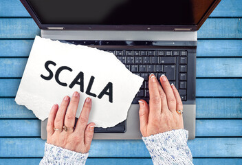 Poster - Scala programming language. Word Scala on paper and laptop