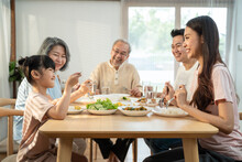 Asian Big Family Enjoy Eating Food Together, Sitting On Dining Table.