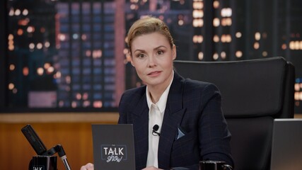 Wall Mural - Portrait of late-night talk show female host having a conversation with celebrity guest in a studio. TV broadcast style show