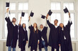 © Studio Romantic - Persons are happy to be graduates. Group of multiracial graduate students lift up their academic hats standing in classroom. Concept of successful completion of an important educational stage in life.