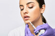 © Peakstock - Lip augmentation procedure. Syringe with lips filler near beautiful woman's mouth, injections for increase lips shape
