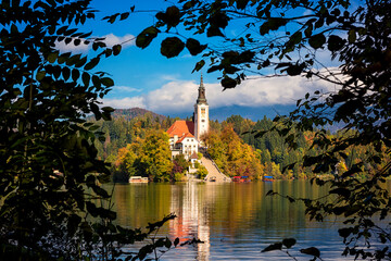 Wall Mural - Famous alpine Bled lake (Blejsko jezero) in Slovenia, amazing autumn landscape. Scenic view of the lake, island with church, blue sky with clouds and reflection in the water, outdoor travel background