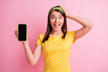 Poster - Photo of young beautiful excited happy cheerful crazy girl hold hand head demonstrate phone isolated on pink color background