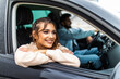 © F8  \ Suport Ukraine - Careful driving. Beautiful young indian couple sitting on the front passenger seats and smiling while handsome man driving a car