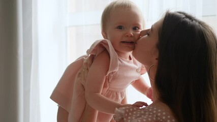 mother and daughter in pink dresses at a large window