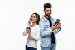 © F8  \ Suport Ukraine - Portrait of attractive indian couple holding in phone, girl worrying looking at guy's chat isolated over white background