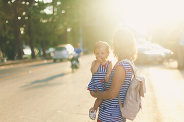 Wall Mural - Happy grandmother lifting up her little granddaughter and hugging in garden at sunny day outdoors. Beautiful middle aged woman and cute small girl. Travel with toddler. Mother's family day