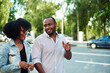 © etonastenka - A couple of black people walk around the city and communicate with each other. An African American woman and a black man chat about the news of the day