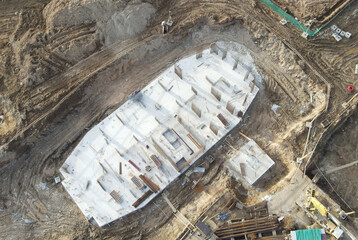 Poster - Drone view of a large construction site. Out of focus, possible granularity, motion blur. Sharpening noise, or film grain that detracts from the main subject.