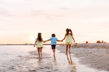 Wall Mural - Little children having fun on sea beach