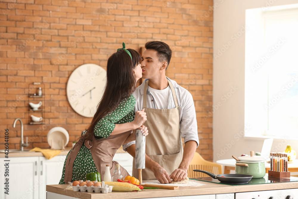 Happy young couple cooking in kitchen