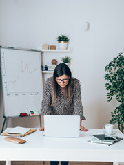 Wall Mural - Successful female CEO reporting business statistic on a web conference from home office.
Tired businesswoman teleconferencing on video call presenting charts and graphs on whiteboard