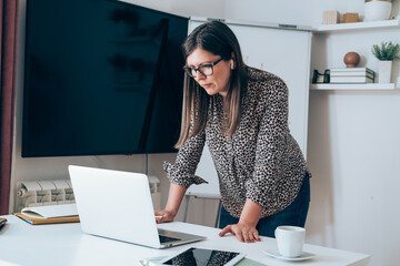 Wall Mural - Businesswoman talking on web conference meeting with colleagues during the coronavirus shutdown
Business woman with bluetooth earphones standing and discuss with clients or coworkers at video call 