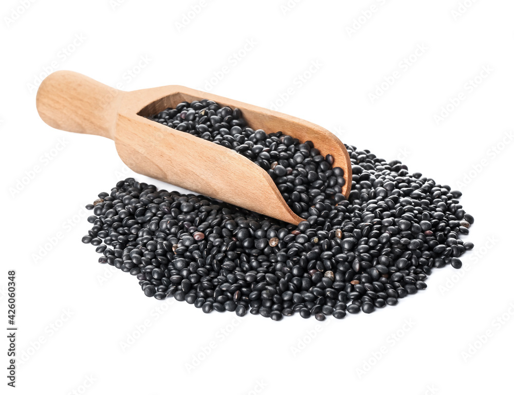 Scoop with black lentils on white background