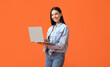 © Pixel-Shot - Young woman with laptop on color background