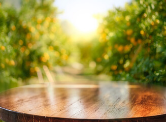 Empty wood table with free space over orange trees, orange field background. For product display montage