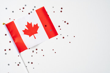 Happy Canada Day greeting card poster with Canadian flag and confetti on white background. Flat lay, top view.