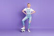 Full size photo of young girl happy positive smile play football game isolated over purple color background
