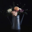 Watering can with flowers, looking like an old still life painting, vintage and shabby mood