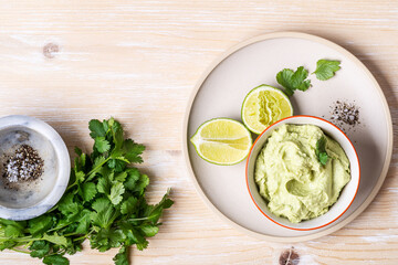 Wall Mural - Avocado hummus dip on rustic wooden table, top view