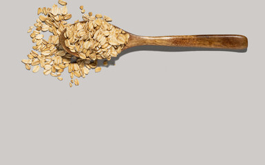 wooden spoon and oatmeal on gray background