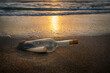 © Tetra Images - United States, Florida, Boca Raton, Glass bottle with message inside on beach at sunset
