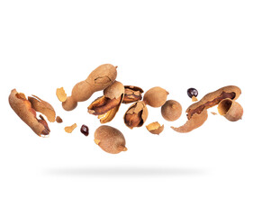 Wall Mural - Crushed tamarind fruits in the air on white background