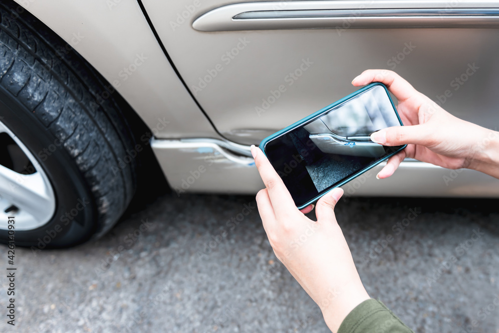 A woman using a mobile phone Take photos of the damage of the car, Which caused by a crash accident As evidence for insurance agents, to people and transportation insurance concept. - obrazy, fototapety, plakaty 