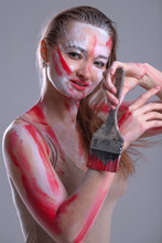 Young Woman With Coloring Brush Soiled In White And Red Paint