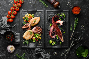 Set of seafood dishes. Fish, squid, octopus on a black stone background. Top view. Free space for your text.